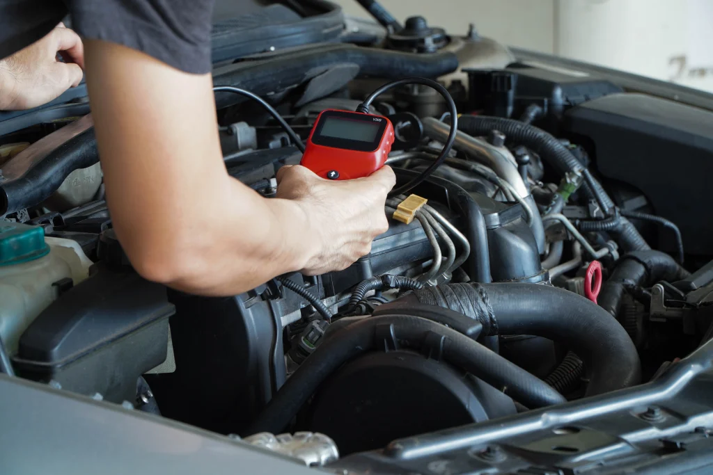 A mechanic connecting a diagnostic scanner to an OBD-II port
